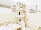 Thumbnail 10 of 17 - bathroom with sink vanity, toilet, and mirror, and model decor