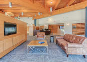 Thumbnail 6 of 24 - Couch, coffee table, and TV in lobby at St. Giles Manor