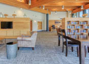 Thumbnail 11 of 24 - large lobby with tables, chairs, and shelves full of books