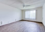 Thumbnail 18 of 24 - spacious bedroom with ceiling fan, large windows, and hardwood-style floors