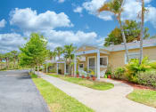 Thumbnail 3 of 15 - trim landscaping, neat sidewalks, and mature landscaping in front of villas