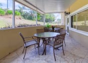 Thumbnail 14 of 15 - Patio with tables, chairs, and fan, and large windows