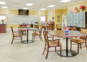 Thumbnail 12 of 15 - Community room with tables and chairs and TV
