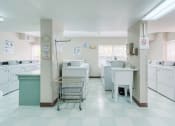 Thumbnail 23 of 23 - large laundry center with washers, dryers, carts, folding tables, and sinks