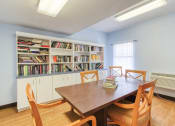 Thumbnail 13 of 23 - library reading room with many books and large table with chairs