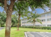 Thumbnail 3 of 23 - Parking lot surrounded by lush landscaping outside Villa Madonna