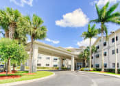 Thumbnail 2 of 16 - Covered drive entrance to Villa Regina and towering palm trees