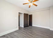 Thumbnail 12 of 15 - a bedroom with hardwood floors and a ceiling fan
