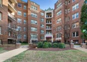 Thumbnail 15 of 15 - a large brick building with a grassy area in front of it
