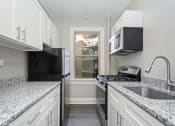 Thumbnail 10 of 15 - a kitchen with white cabinets and a window