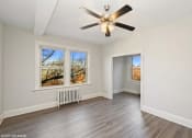 Thumbnail 9 of 15 - an empty bedroom with a ceiling fan and three windows