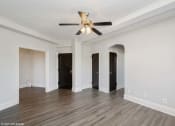 Thumbnail 8 of 15 - a living room with white walls and a ceiling fan