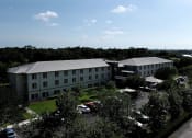 Thumbnail 11 of 12 - Villa Vincente Senior Apartments in For Myers, FL surrounded by trees beside water