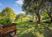 Thumbnail 10 of 12 - lush landscaping with garden boxes, mature trees, and picnic tables