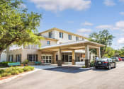 Thumbnail 1 of 12 - covered drive up entrance to Villa Vincente Senior Apartments in Fort Myers, FL