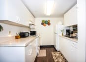 Thumbnail 4 of 12 - kitchen with white cabinets and appliances at Villa Vincente