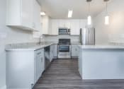 Thumbnail 5 of 17 - Alternate view of kitchen with stone counters, white cabinets, stainless appliances