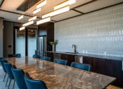 Thumbnail 69 of 75 - conference room with large table and blue chairs and a countertop with a sink behind it at The Apex at CityPlace, Overland Park, Kansas