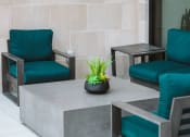 Thumbnail 70 of 75 - outdoor seating area with 3 blue lounge chairs around a square gray table at The Apex at CityPlace, Overland Park