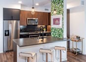 Thumbnail 34 of 53 - Kitchen with stainless steel appliances and bar stools at Vida North Park, San Diego, California