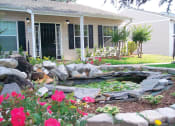 Thumbnail 2 of 18 - small pond and pink flowers in front of leasing office