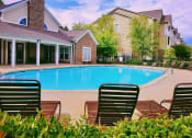 Thumbnail 5 of 13 - The sparkling pool and large sundeck by the clubhouse at Lumpkin Park Apartments