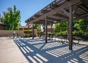 Thumbnail 7 of 18 - a picnic area with benches and tables under awning