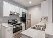 Thumbnail 4 of 18 - a kitchen with white cabinets and stainless steel appliances