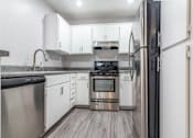 Thumbnail 5 of 18 - a kitchen with white cabinets and stainless steel appliances