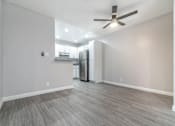 Thumbnail 14 of 18 - an empty living room with a refrigerator and a ceiling fan