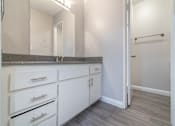Thumbnail 15 of 18 - an empty bathroom with white cabinets and a mirror