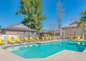 Thumbnail 8 of 22 - Temecula apartments with a swimming pool with yellow chairs