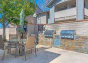 Thumbnail 19 of 22 - a patio with a barbecue grill and a table and chairs