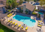 Thumbnail 20 of 22 - swimming pool with yellow chairs and umbrellas around it