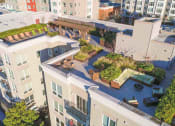 Thumbnail 21 of 22 - A modern apartment complex with green roofs and a courtyard.