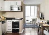 Thumbnail 11 of 33 - Kitchen with stove and table at Wilshire Vermont, Los Angeles, CA