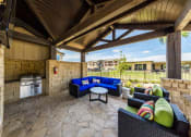 Thumbnail 30 of 39 - BBQ Area Inside Pool Area with Tables & Chairs at Legacy Creekside Apartments, San Antonio
