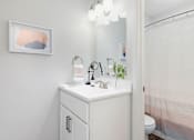 Thumbnail 4 of 21 - Bathroom with white cabinetry and white countertops