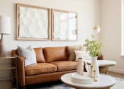 Thumbnail 15 of 36 - Leather sofa in natural lighting, side table with lamp, and small coffee table