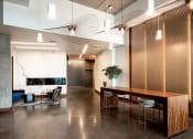Thumbnail 17 of 36 - Lobby with large wooden table and seating for six. Polished concrete floor and marble fire place