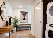 Thumbnail 30 of 36 - Entry foyer with washer and dryer in a closet with small bench and table and mirror