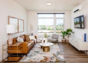 Thumbnail 32 of 36 - Living room with windows facing north, leather sofa, mounted television