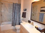 Thumbnail 7 of 26 - A bathroom with a white toilet, a white sink, and a shower.