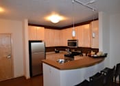 Thumbnail 1 of 26 - A kitchen with a refrigerator, microwave, oven, and sink.