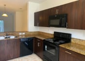 Thumbnail 9 of 18 - kitchen with blank appliances and dark wood cabinetry at Preserve at Boynton Beach, Boynton Beach, 33435