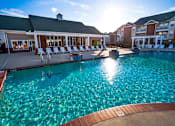 Thumbnail 26 of 29 - sun setting over the pool behide the clubhouse at 1200 Acqua Apartment homes near Fort Lee Virginia
