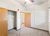 Thumbnail 14 of 31 - a bedroom with a large closet, illuminated ceiling fan, and a window letting in natural light
