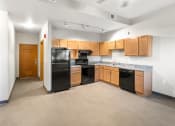 Thumbnail 12 of 31 - a spacious kitchen and living area with efficient appliances and wood cabinets