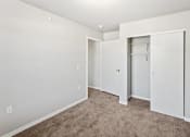 Thumbnail 6 of 31 - a bedroom with white walls, plush carpeting, and a closet at Muskego School
