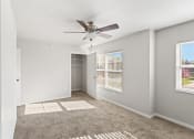 Thumbnail 7 of 31 - a spacious room with carpet, a ceiling fan, and ample natural light from large windows